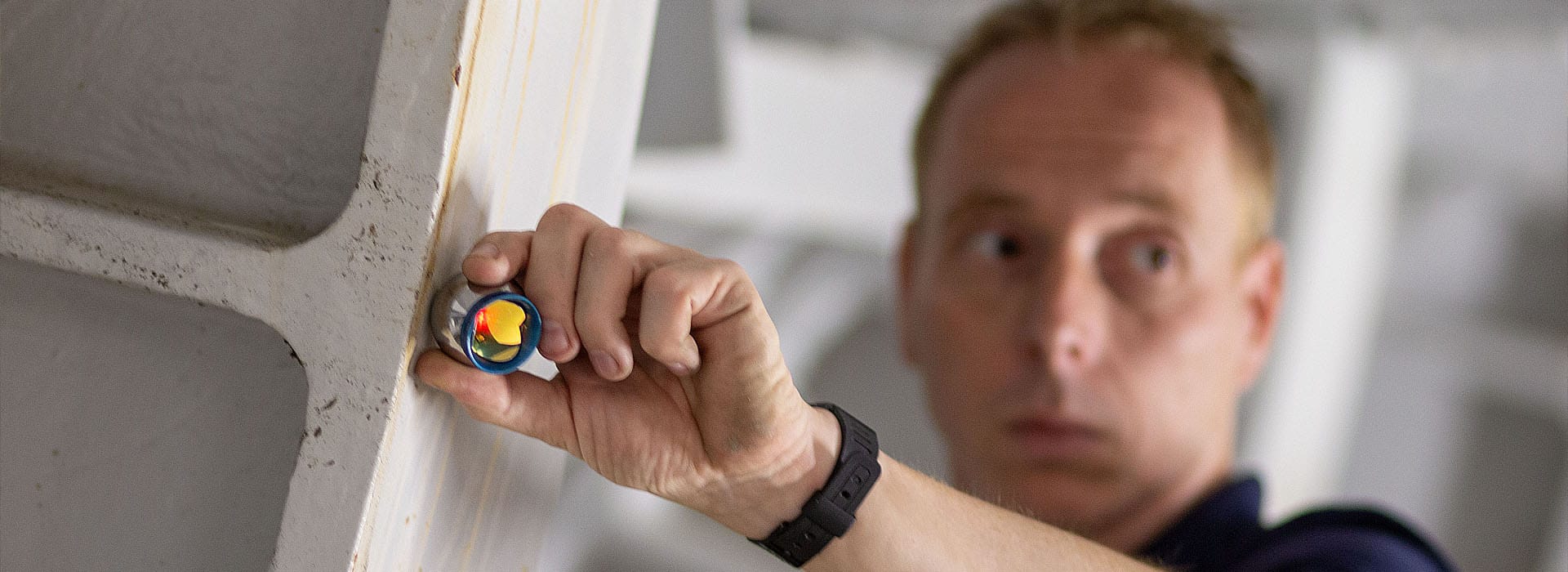 3D-meetspecialist controleert een staalconstructie met een meetprisma voor nauwkeurige industriële maatvoering.