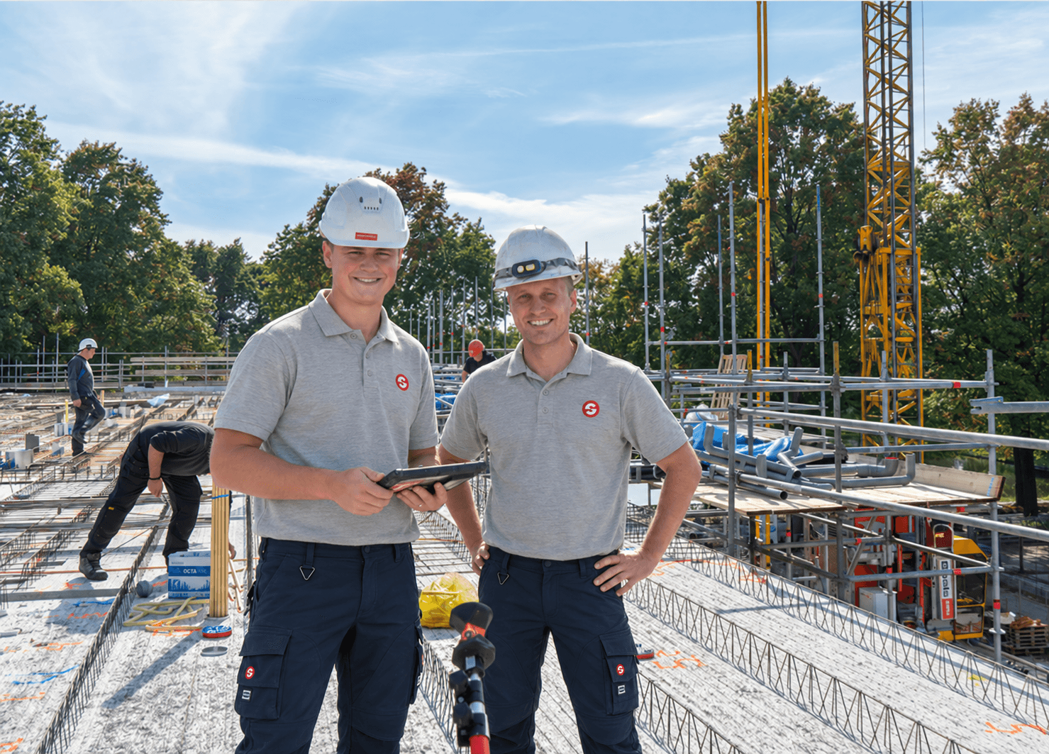 Maatvoerders voeren bouwmaatvoering uit met total stations in een bedrijfshal voor nauwkeurige plaatsing van constructies.