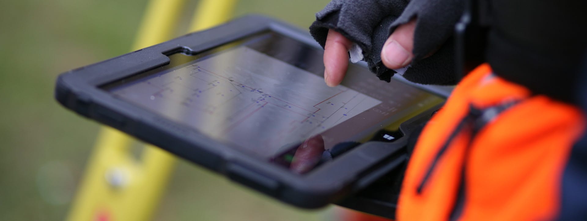 Maatvoerder gebruikt een tablet met digitale bouwtekening voor nauwkeurige bouwmaatvoering op locatie.